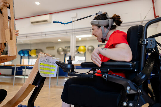Woman with head pointer using assistive technology for rehabilitation