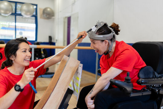 Woman with head pointer using assistive technology learning