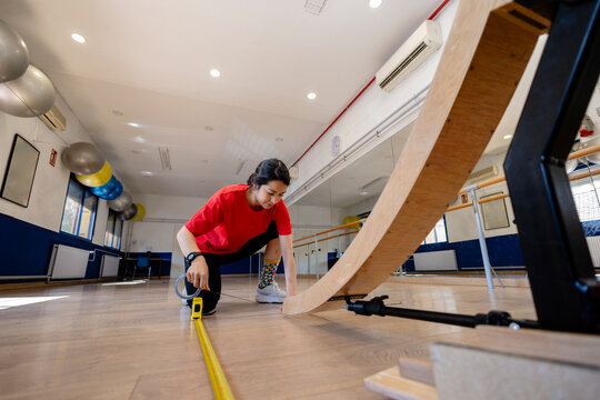 Student measuring a wooden ramp in a university lab