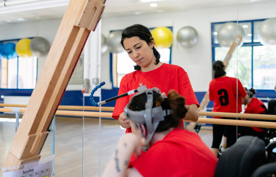 Therapist adjusting assistive technology device for person
