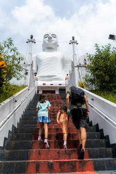 Family Climbing Steps to Majestic Buddha Statue, Kandy, Sri Lanka