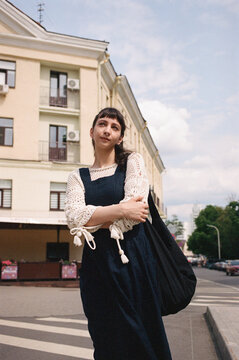 Young woman walks on the street holding a bag