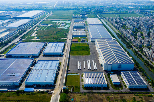 industrial park with solar rooftops beside residential city