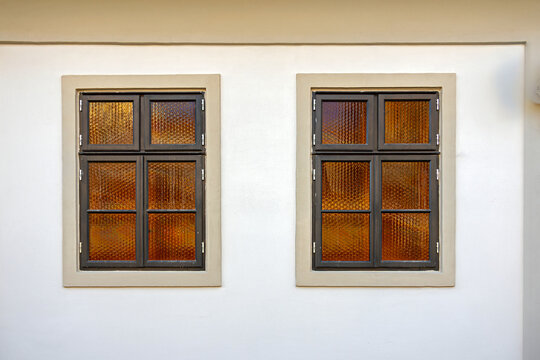 Old retro closed brown glass windows on stone facade wall