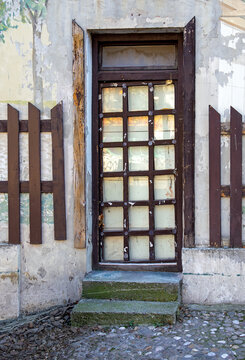 Old closed dirty entrance door with wooden and glass frame