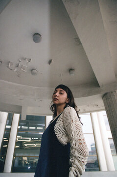 Woman stands under old ceiling structure in urban space