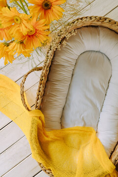 Empty boho baby basket bed with yellow flowers