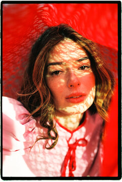 Woman's portrait with red pattern shadows on face