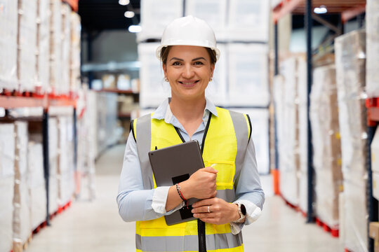 Woman warehouse worker managing logistics with tablet