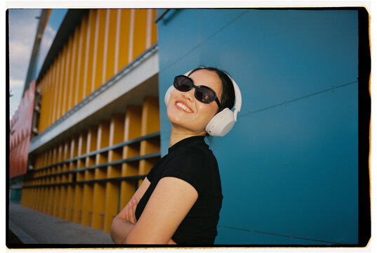 Smiling Woman Wearing Wireless Headphones and Sunglasses