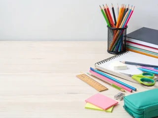 Schulmaterial mit Buntstiften, Heften, Büchern, Lineal und Federmäppchen auf hellem Holztisch. Modernes Schulanfang-Konzept aus Deutschland mit großzügiger freier Fläche für Text. © superstock