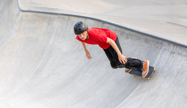 Skateboarder riding concrete bowl
