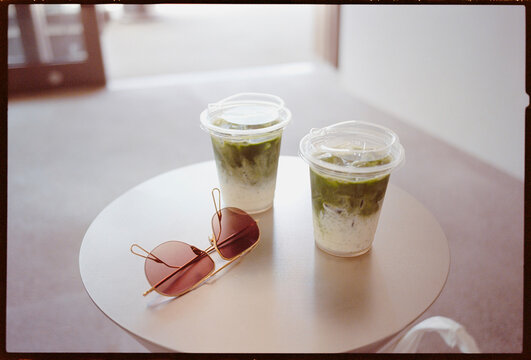 Matcha Drinks on a Table With Sunglasses at a Cafe in the Afternoon
