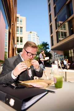 Businessman eats street food in London.