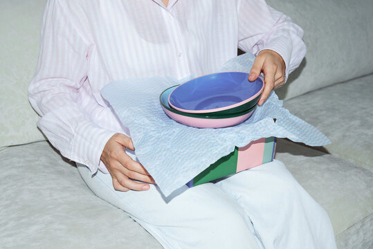 Anonymous woman unpacking two plates