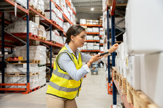 Woman warehouse worker scanning packages in distribution center