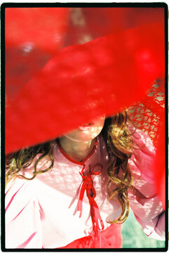Woman hiding face with red fabric