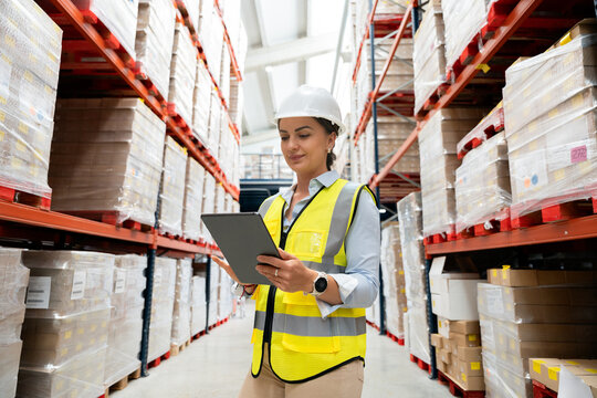 Woman manager checking inventory on digital tablet in warehouse