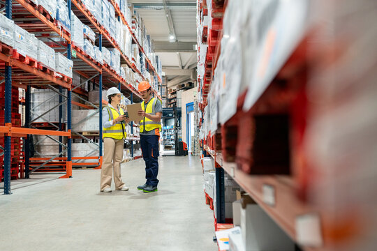 Warehouse workers discussing logistics and inventory management