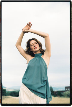 Woman outdoors with arms raised