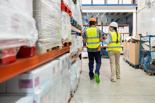 Warehouse workers discussing inventory management in logistics center