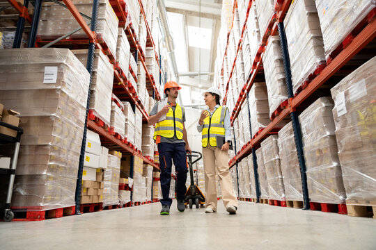Warehouse workers discussing logistics and inventory management