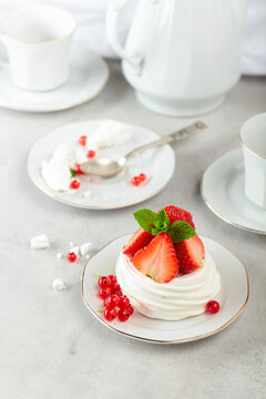 Pavlova dessert with strawberries, red currant, and mint.