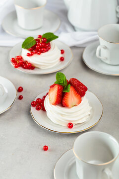 Pavlova dessert with strawberries, red currant, and mint.