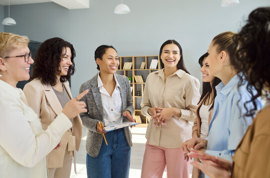 Women team meeting discussion coaching training teamwork. Smiling colleagues in a modern office share ideas with open communication and leadership. Ideal for HR, mentoring, and diversity.