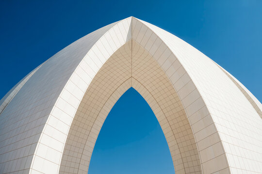 Low Angle Minimalist White Geometric Arch Structure Against Clear Blue Sky