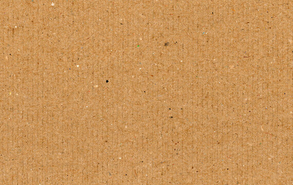 Pebbled cardboard texture presses rough recycled fibers into a dense paperboard face whose grain supports kraft collage distressed paint marks packaging studies and rugged surface sampling