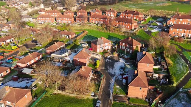 Drone's-eye winter view captures Dewsbury Moore Council estate's typical UK urban council-owned housing development with red-brick terraced homes and the industrial Yorkshire. Working class housing