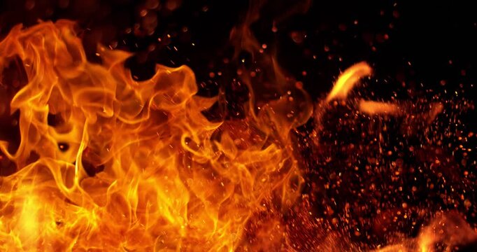 Ultra slow motion fire flames with glowing embers and sparks on black background captured at 1000 FPS. Dramatic combustion effect ideal for cinematic overlays and visual effects.