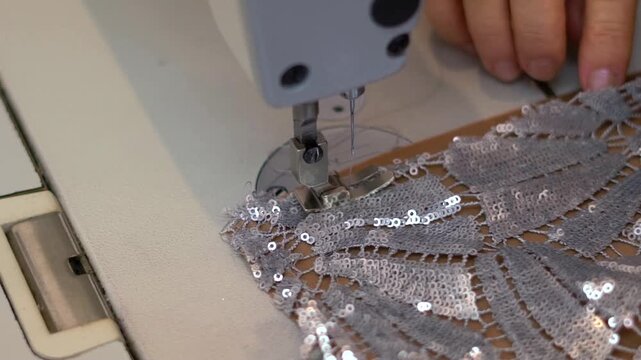 Macro shot of hands sewing with a sewing machine and fabric