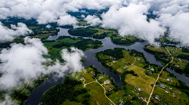 Aerial landscape with winding river, green fields and houses, beautiful view.