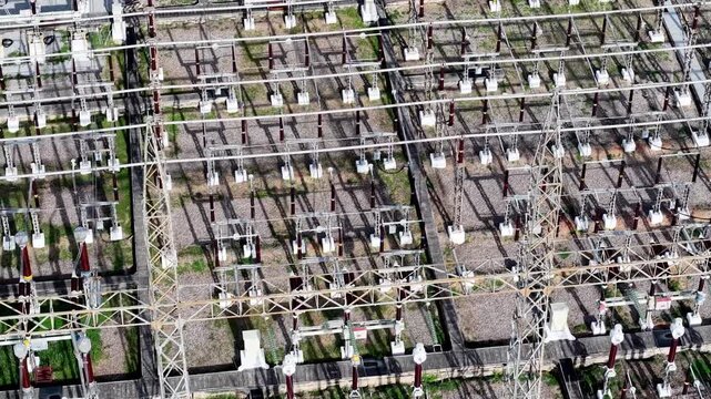 Aerial view of a large electrical substation. Metal structures line the ground in rows