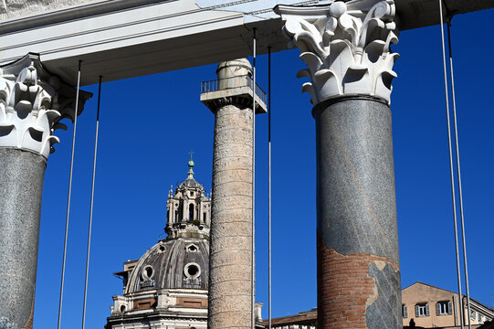 reconstructed, rebuilt old archeological remnants of temple and structure in Rome, Italy. white stone, smooth gray concrete columns and structural steel cables. old church cupola between the columns