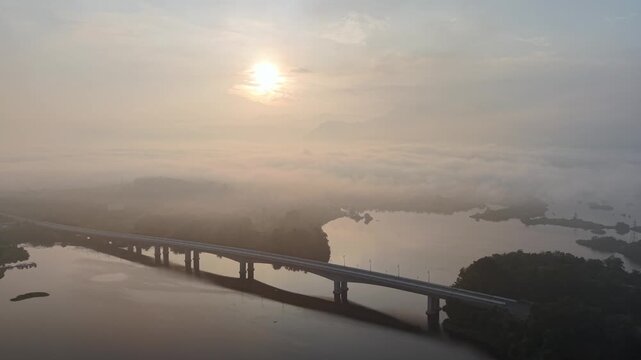 Dawn light reveals a long bridge spanning a river at Tasik Raban