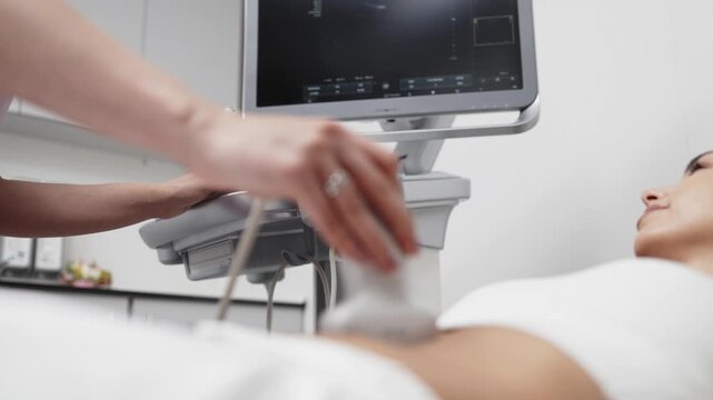 Ultrasound specialist examining the abdominal cavity of a young woman in a bright medical office. Concept abdominal ultrasound, diagnostic imaging, healthcare, preventive medicine, medical examination