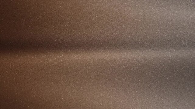 Abstract shimmering bronze metal textured background with blurred highlights and gentle gradients for modern designs