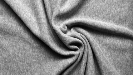 textured heather grey cotton jersey fabric twists into a soft spiral fold for cozy sustainable fashion background © Arthur