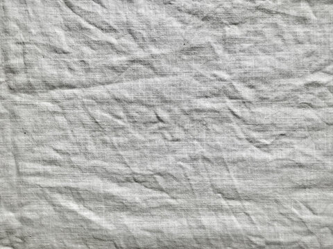 organic wrinkled white linen fabric texture with deep creases for sustainable packaging and minimalist web design