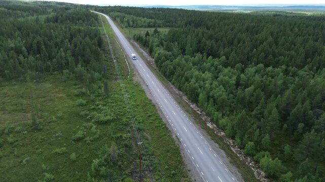campingcar passing a road in sweden all alone next to a forest