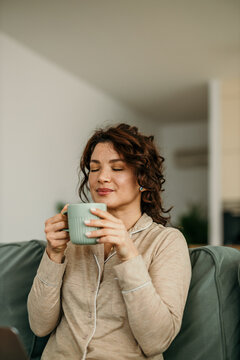 Woman enjoying morning coffee at home feeling relaxed