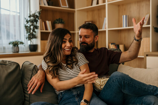 Happy couple relaxing at home watching movie