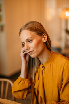 Woman with blond hair contemplating indoors