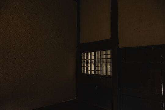 薄暗い土壁の部屋に浮かび上がる明かり取りの障子窓