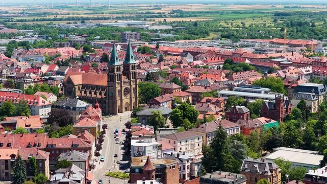 Malerischer Blick &uuml;ber die roten Ziegeld&auml;cher der Altstadt von Landau in der Pfalz mit den markanten Doppelt&uuml;rmen der neoromanischen Stadtpfarrkirche St. Maria im Zentrum.