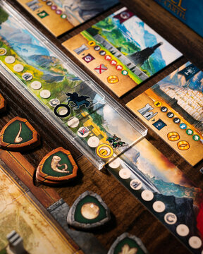 Portrait macro product photography of Lord of the Rings Duel Middle Earth showing Free Peoples faction tokens with horn sphere and tree leaf symbols designed by Antoine Bauza and Bruno Cathala