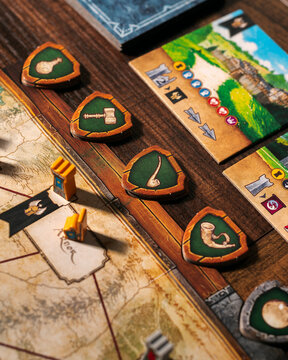 Portrait macro product photography of Lord of the Rings Duel Middle Earth showing Free Peoples faction tokens with horn sphere and tree leaf symbols designed by Antoine Bauza and Bruno Cathala